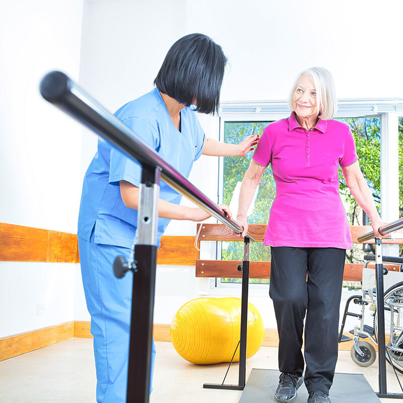 rehabilitation doctor physiotherapist physician and nurse practitioner helping patient lift dumbbell with one hand